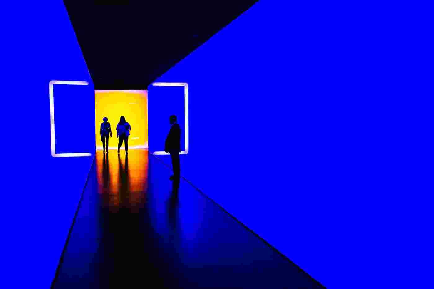 People walking from an orange room to a blue room